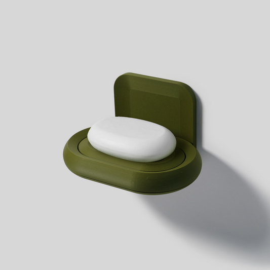 dark Green soap holder with a bar of soap on a light gray background