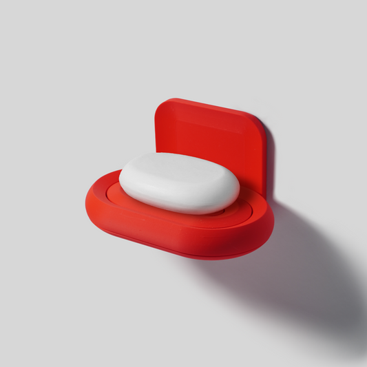 Red soap holder with a bar of soap on a light gray background