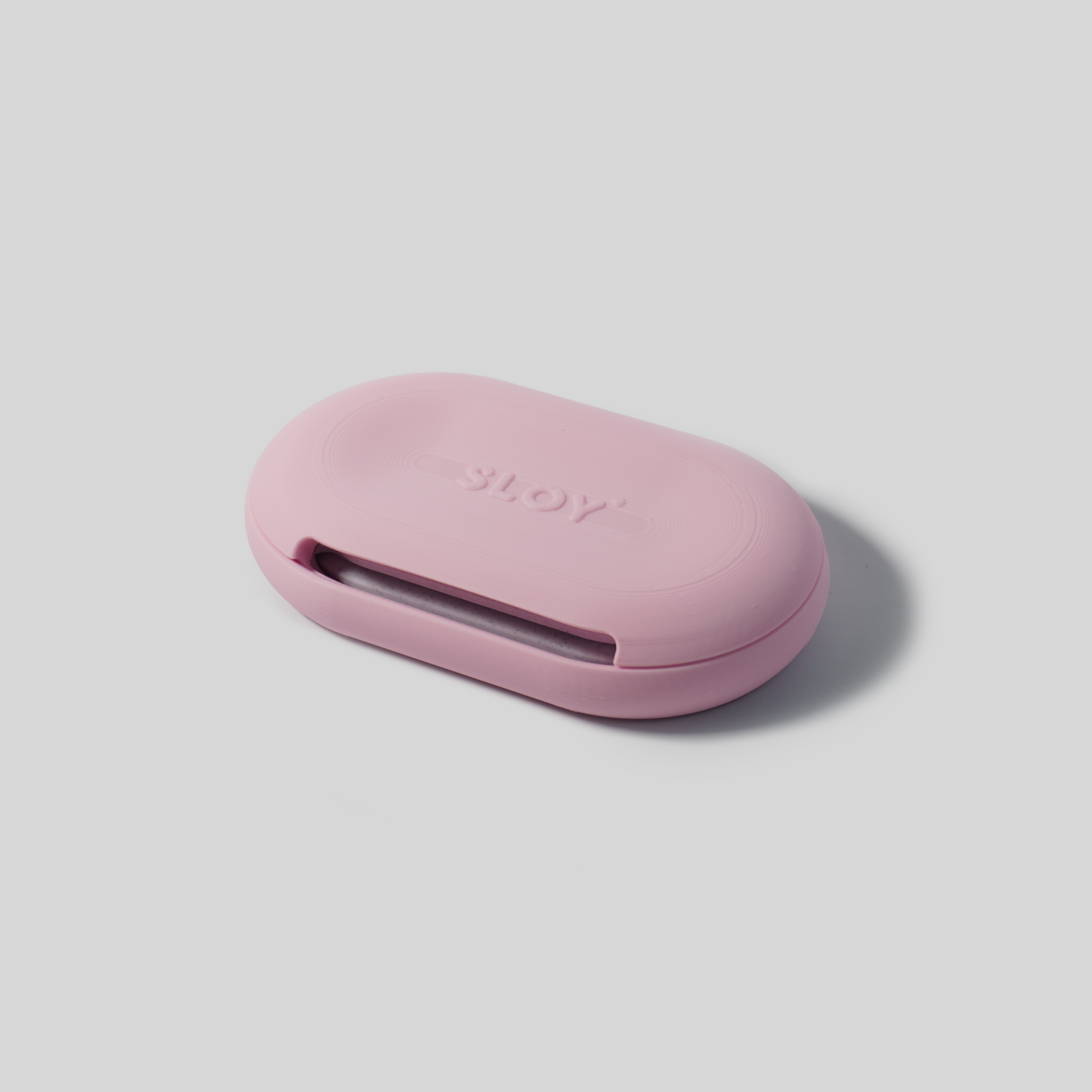 Pink soap holder upside down with 'SLOY' branding on a light gray background