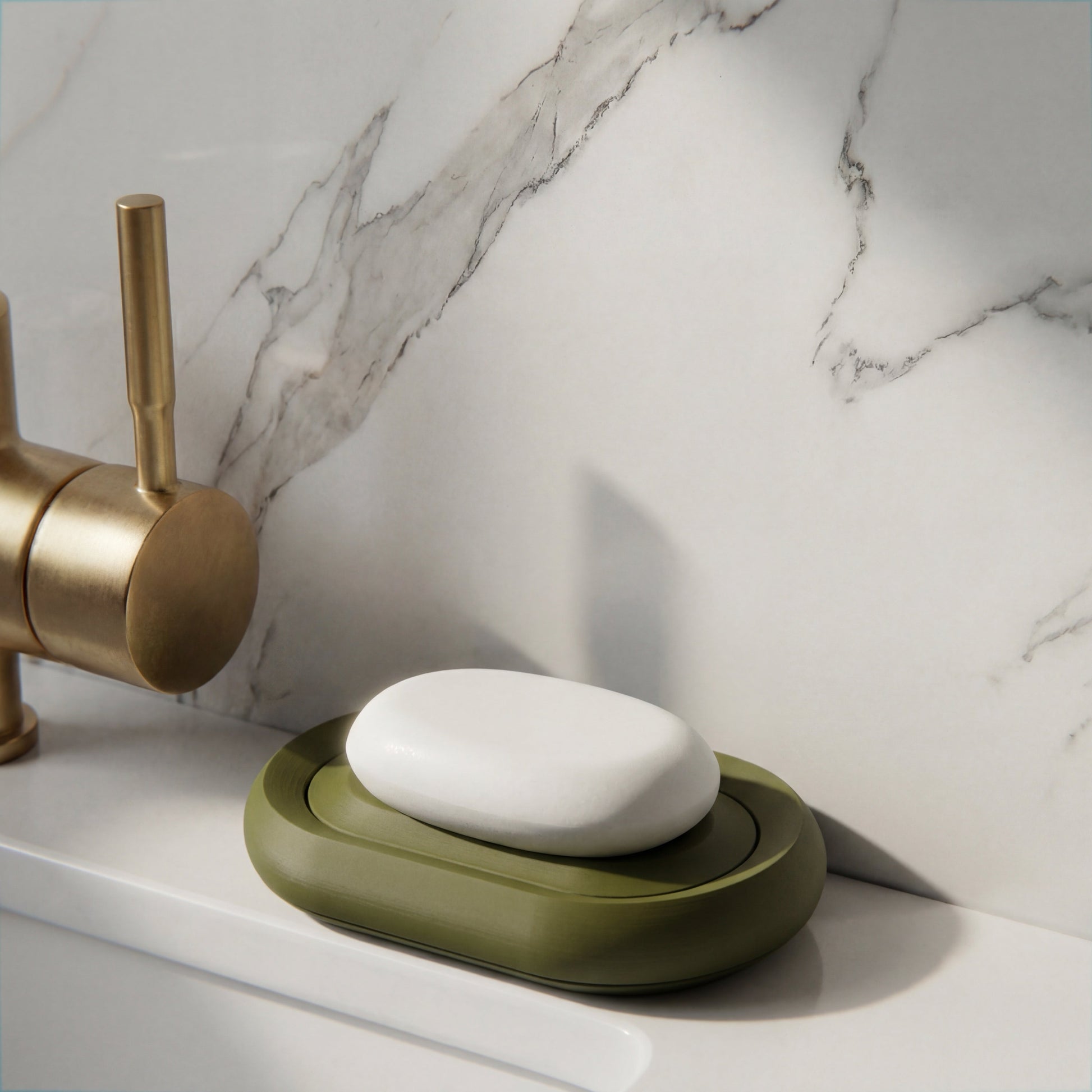 dark Green soap holder with a bar of soap on a marble countertop