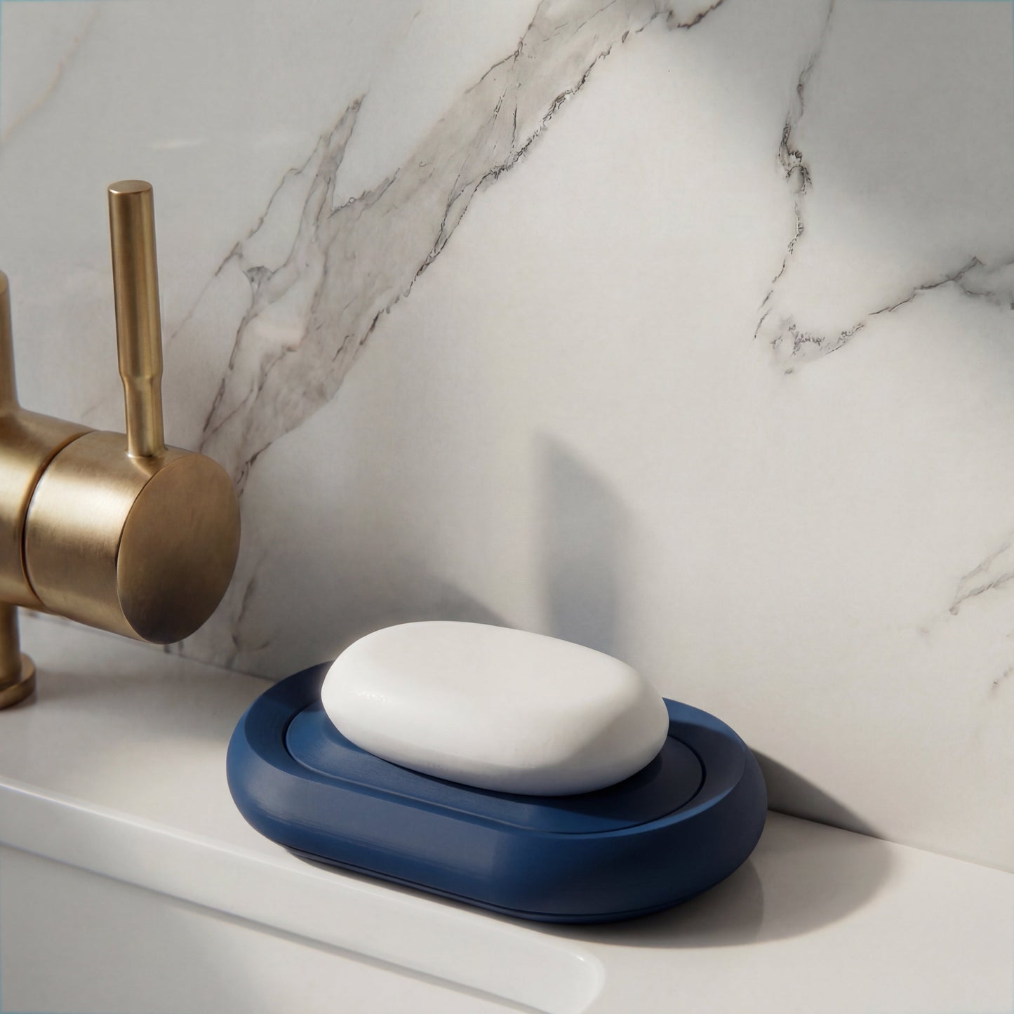 Blue soap holder with a bar of soap on a marble countertop