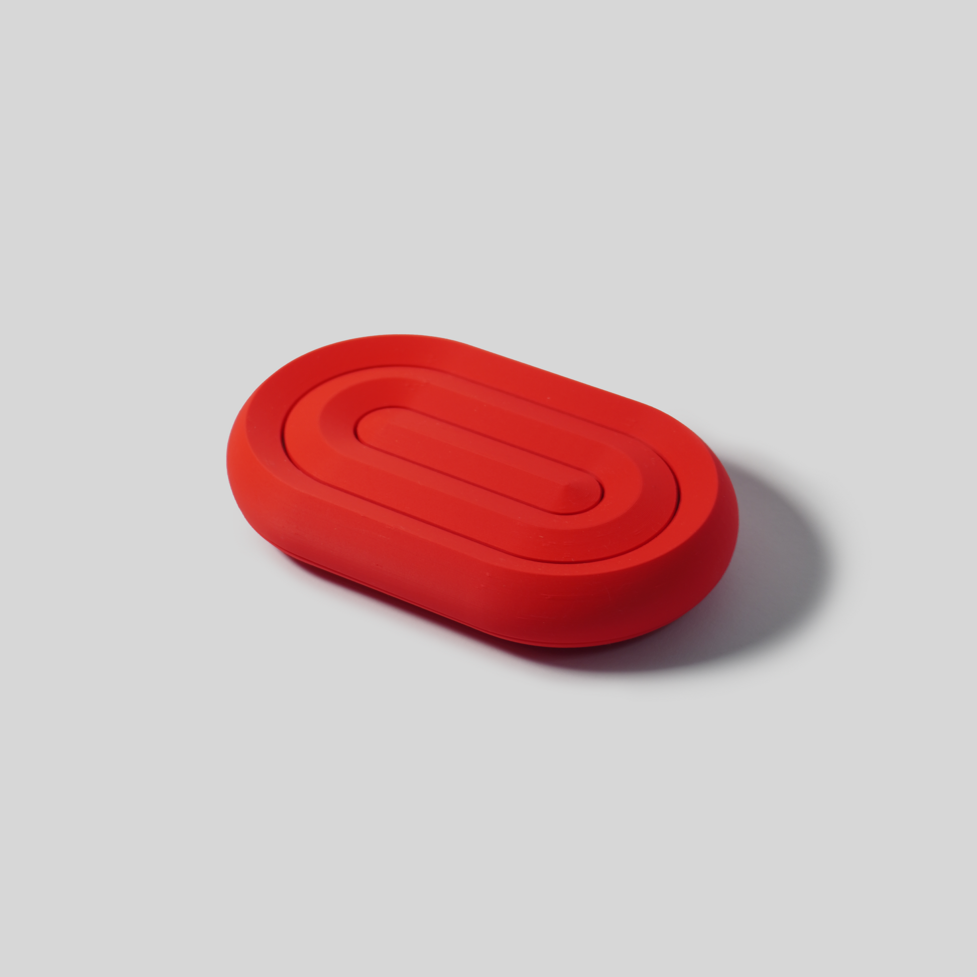 Red oval soap holder on a gray background