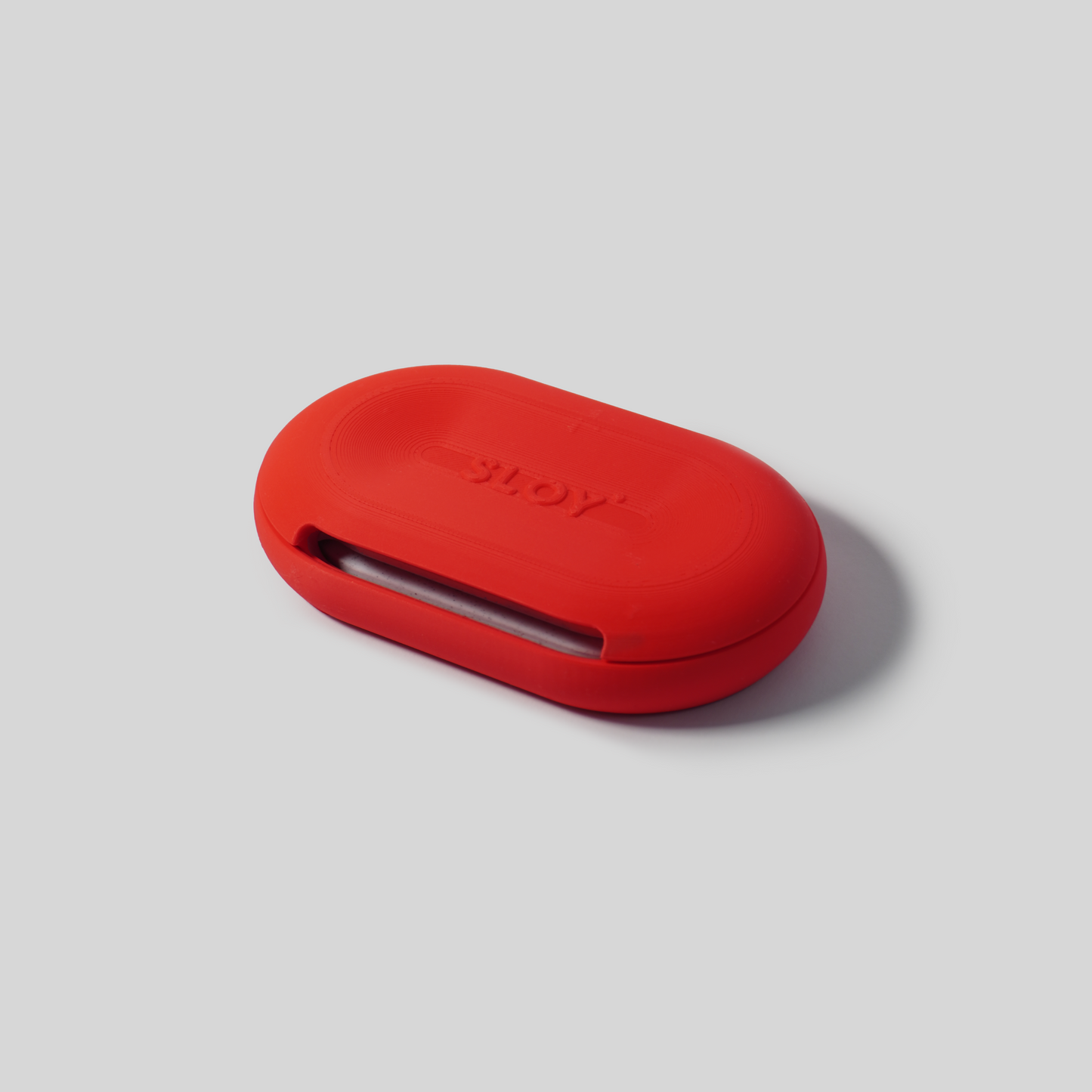 Red oval-shaped soap holder upside down  with 'SLOY' branding on a gray background