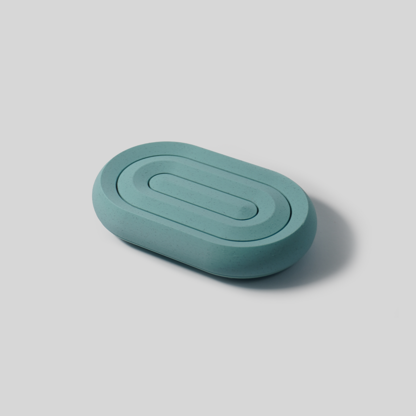 Teal oval soap holder on a light gray background