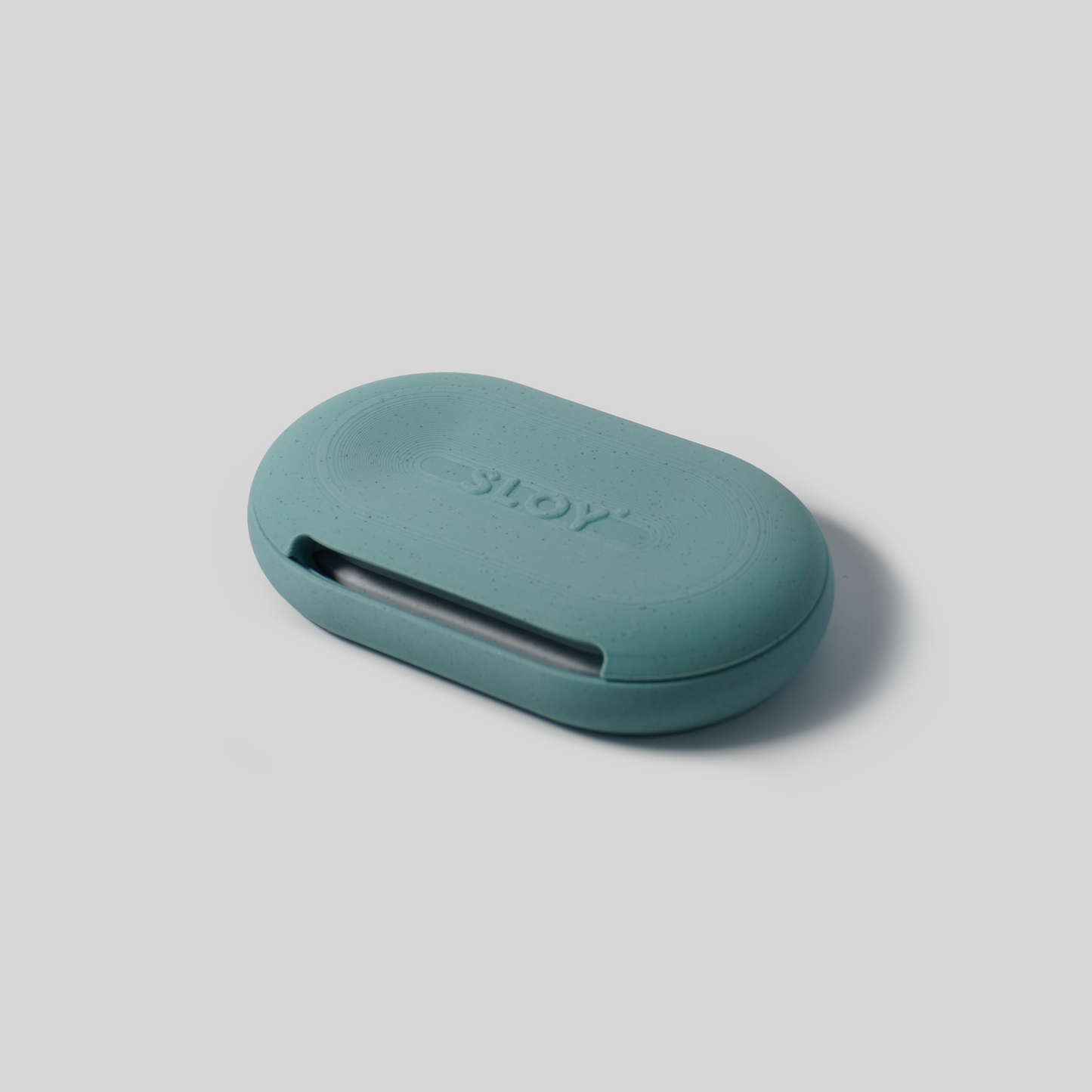 Teal oval-shaped soap holder with 'SLOY' branding on a light gray background