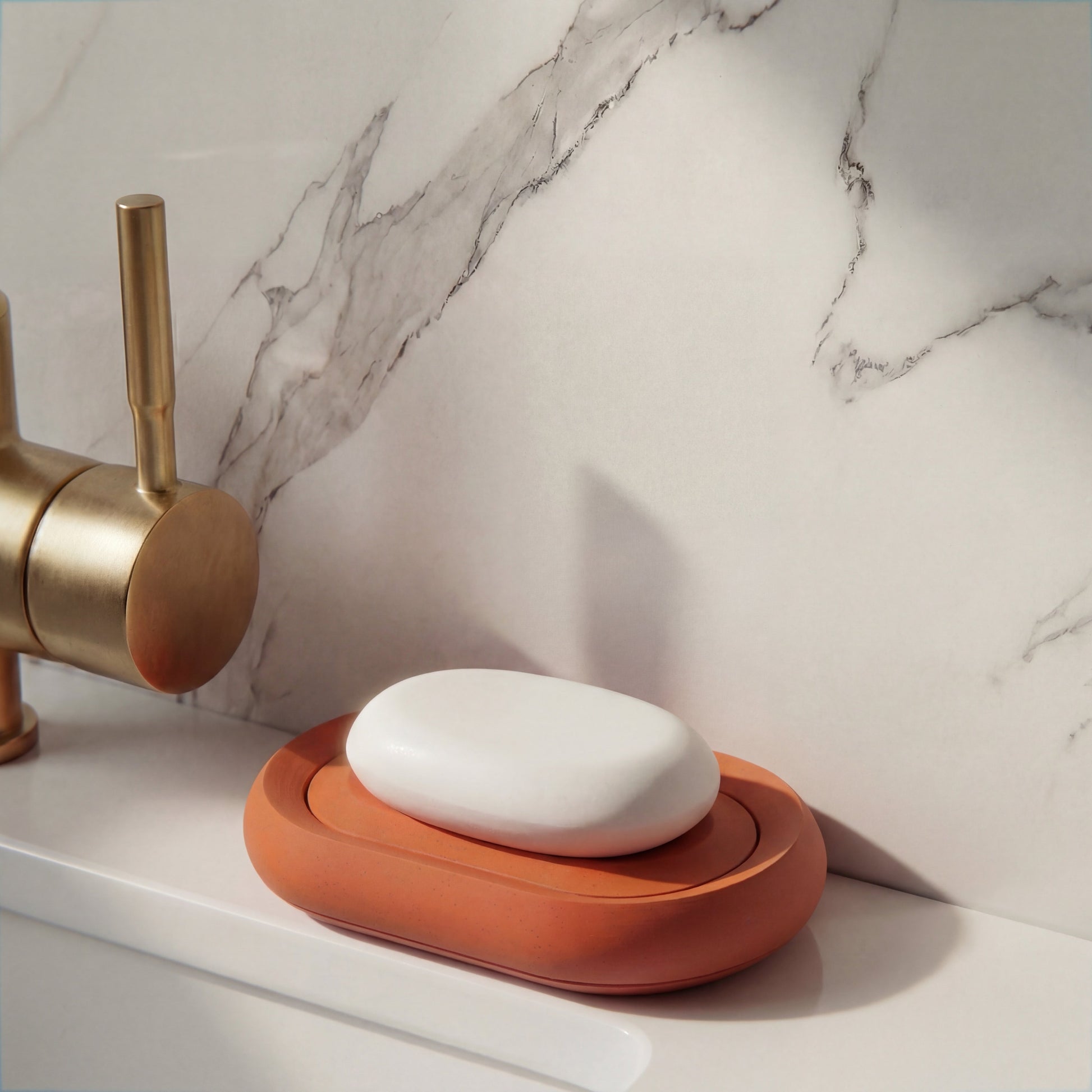 Compact terracotta soap holder on minimalist bathroom sink