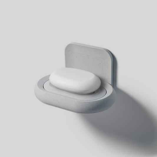 Wall-mounted gray soap holder with a white soap on a light gray background