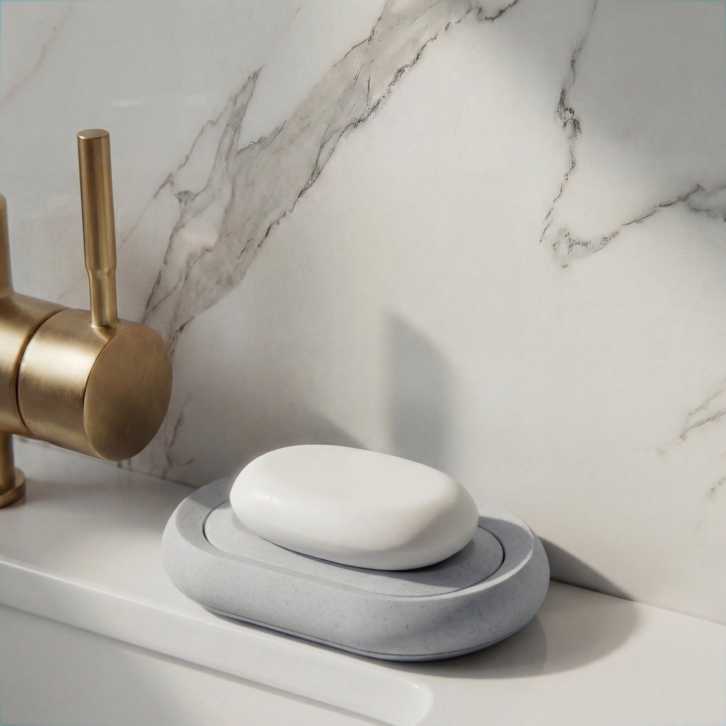 White soap on a gray soap holder with a brass faucet against a marble wall