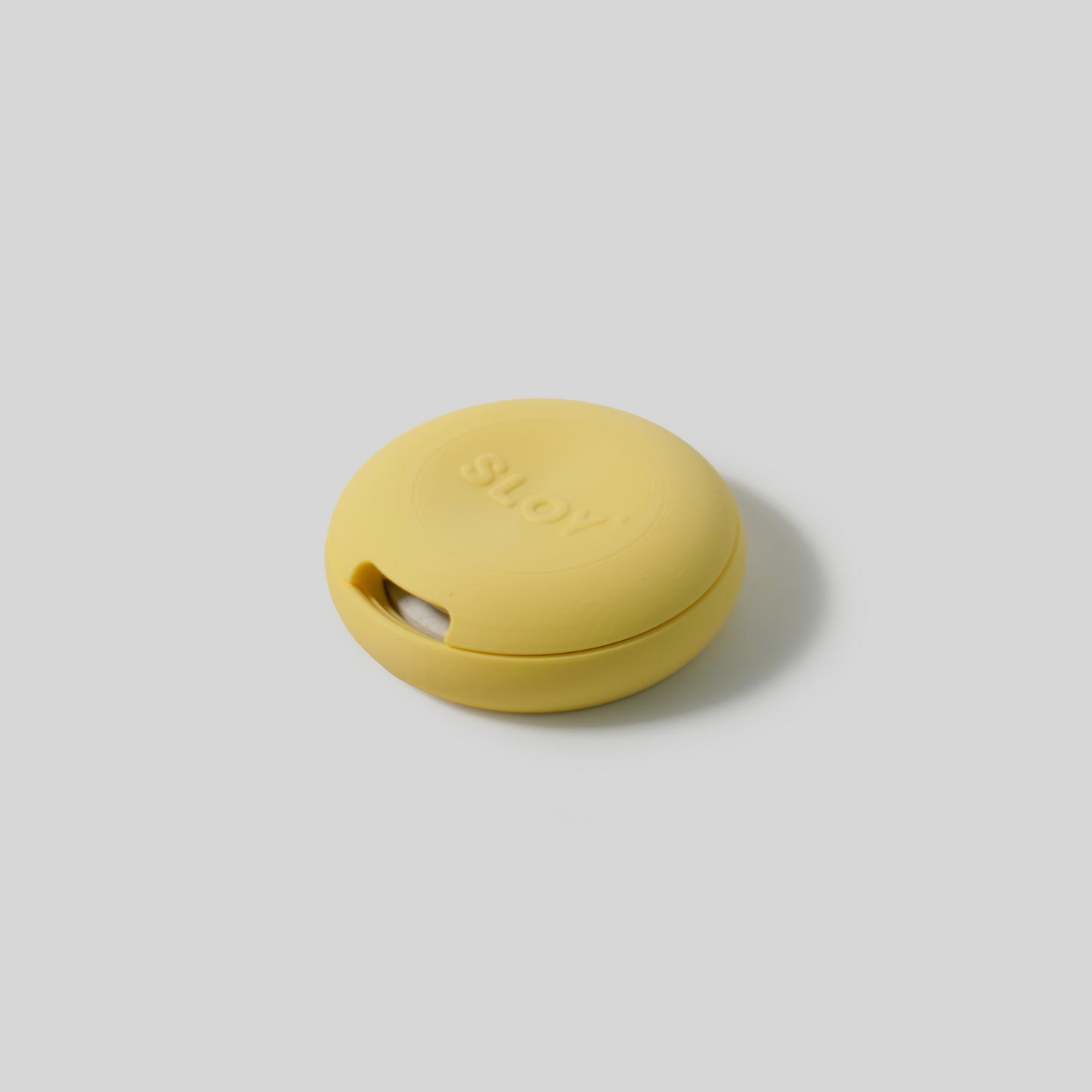 Yellow round soap holder upside down with a brand logo on a light gray background