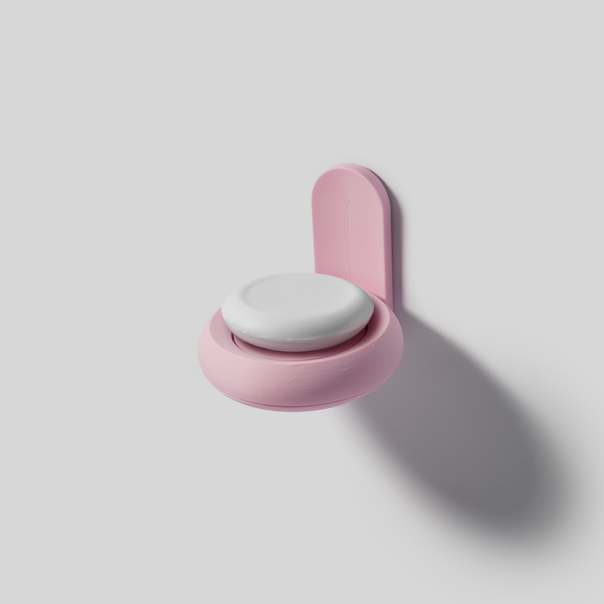 Pink wall-mounted soap holder on a light gray background