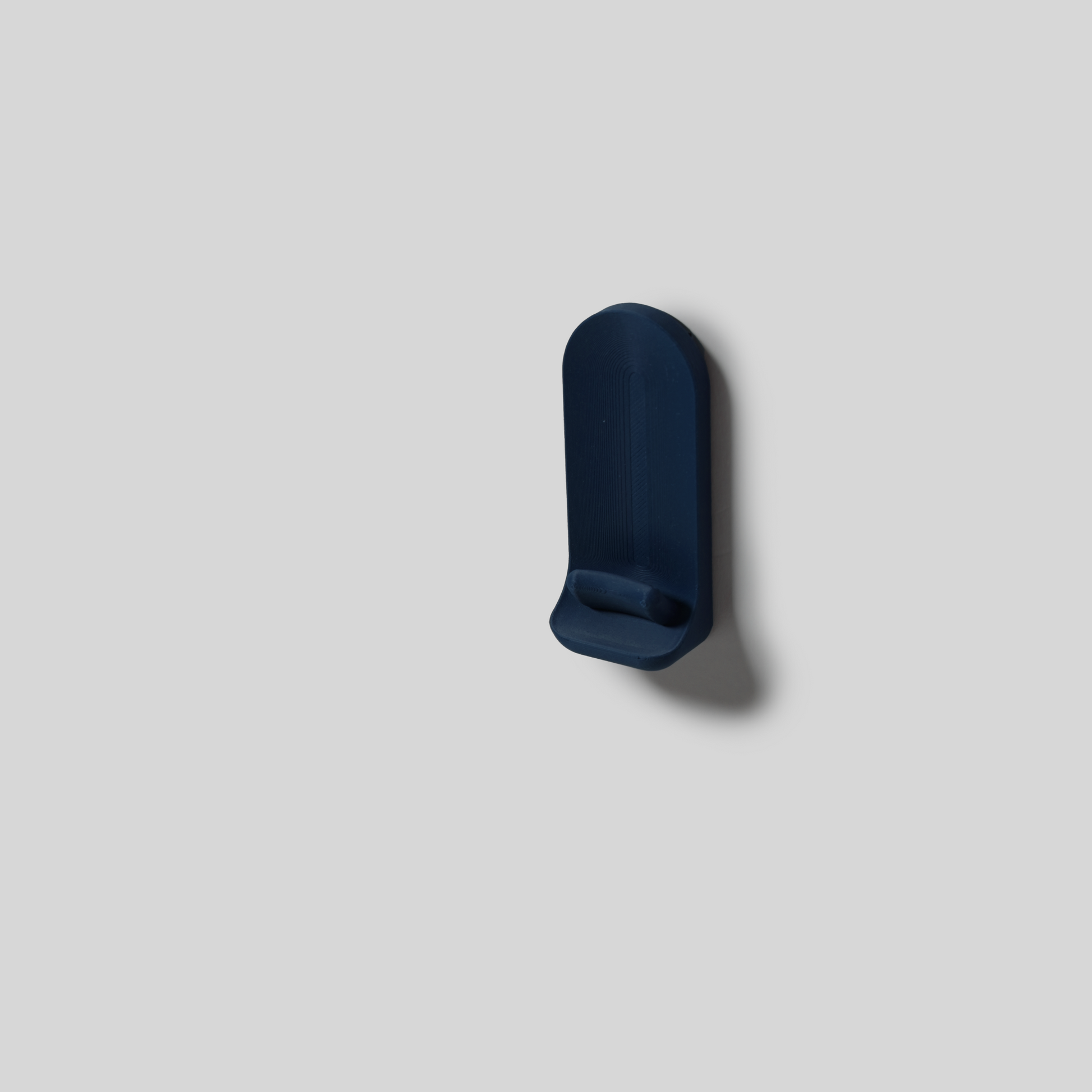 deep blue wall-mount with adhesive on a light gray background