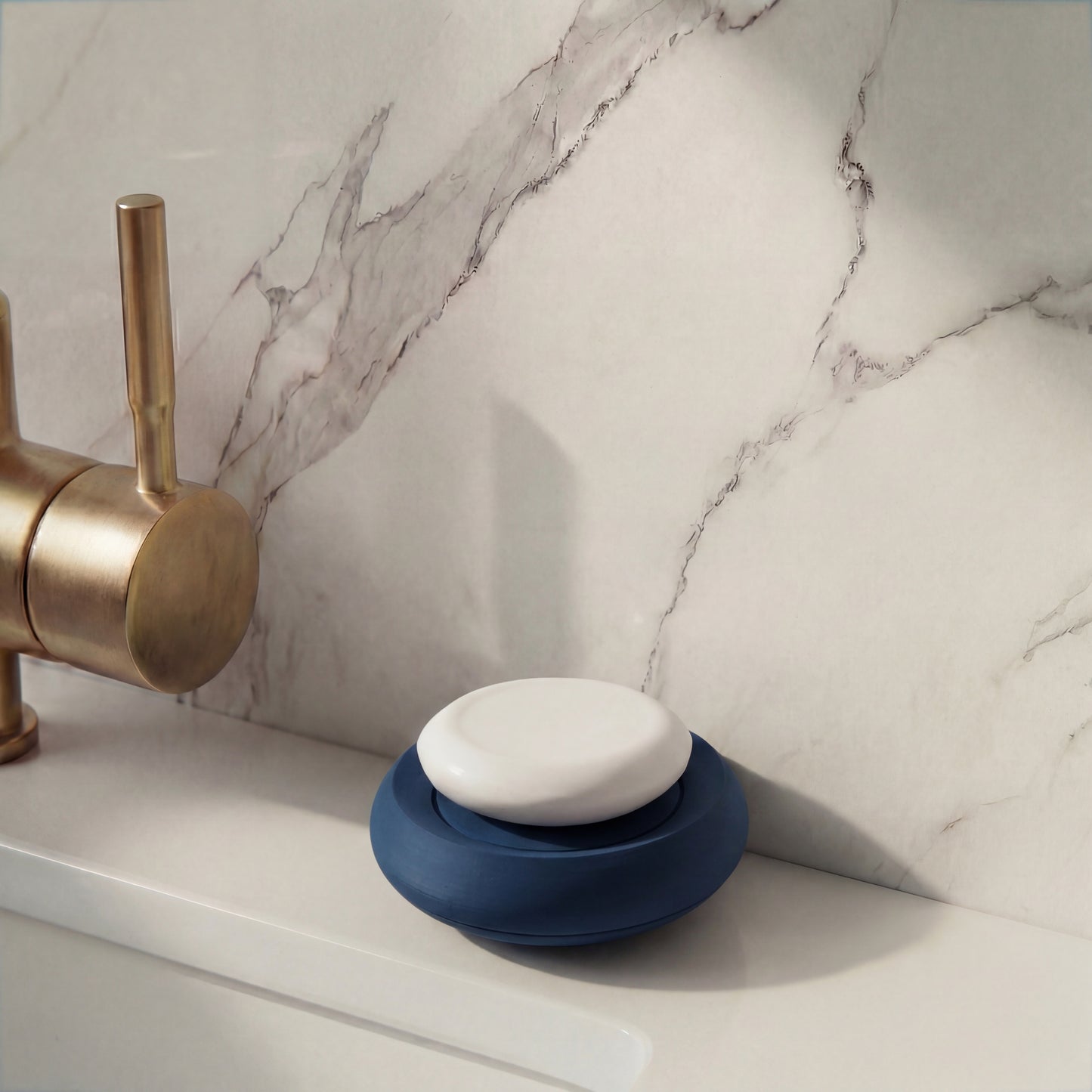Blue soap holder on a marble bathroom counter with a brass faucet PLA hamburg