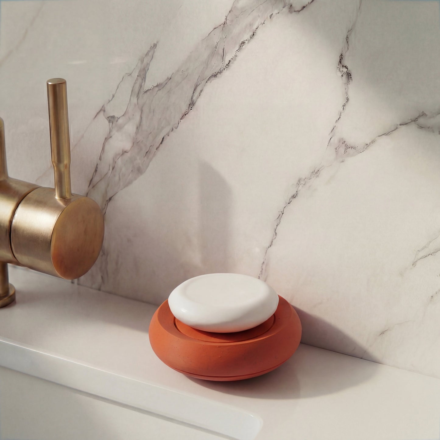 Compact terracotta soap holder on minimalist bathroom sink