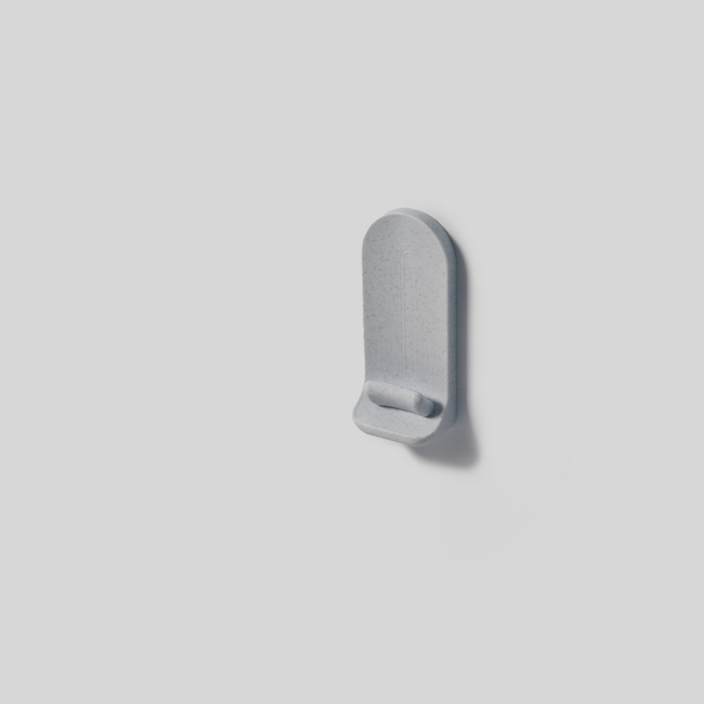 Gray wall mount with adhisive on a light gray background
