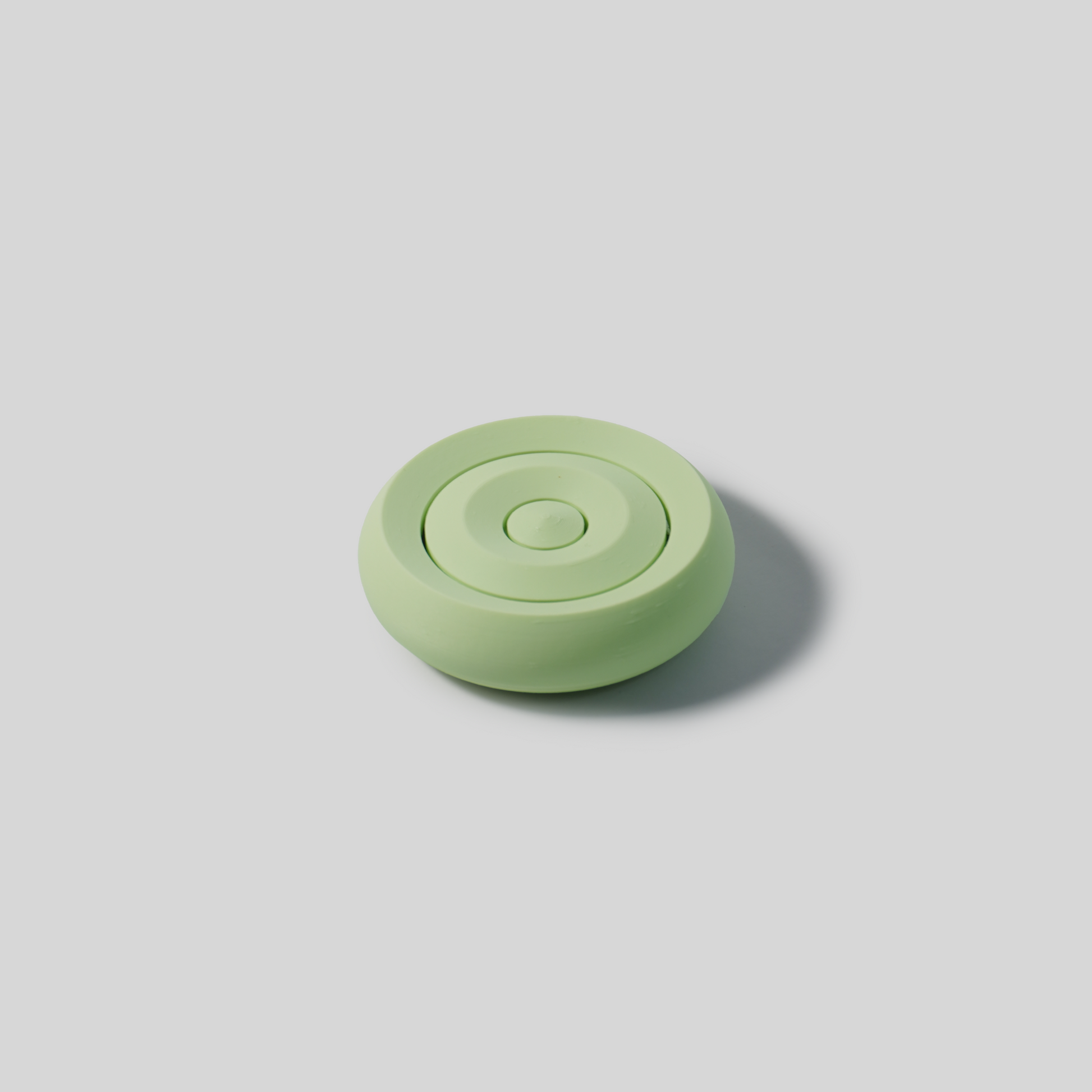 Green mint circular soap holder on a light gray background